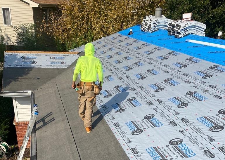Johnson Restoration worker walks roof